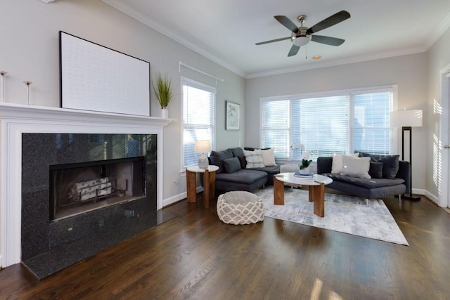 living room with dark wood-type flooring, ceiling fan, ornamental molding, and a premium fireplace