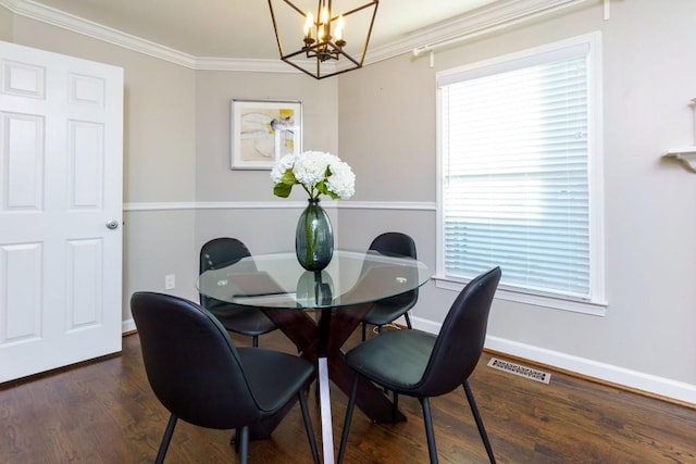 dining space featuring ornamental molding, dark wood-type flooring, and a notable chandelier