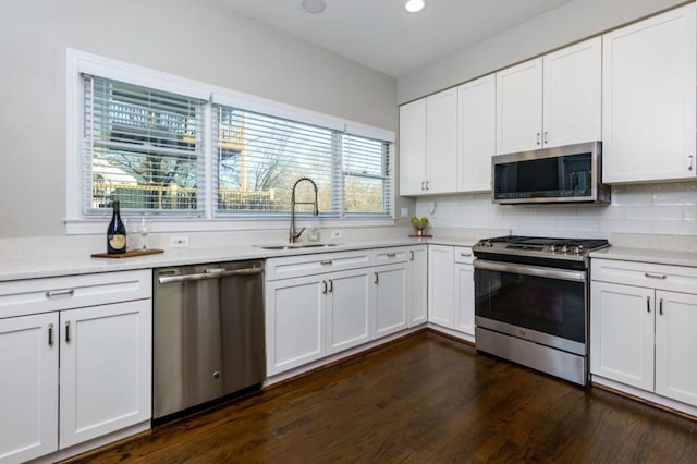 kitchen featuring dark hardwood / wood-style flooring, sink, white cabinets, and appliances with stainless steel finishes