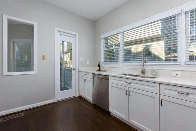 kitchen with sink, stainless steel dishwasher, dark hardwood / wood-style floors, light stone countertops, and white cabinets