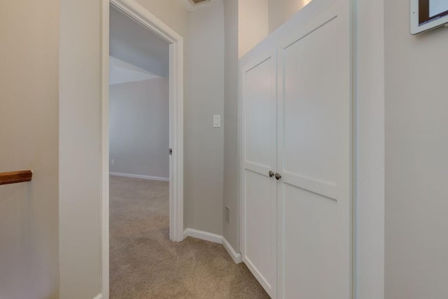 hallway featuring light colored carpet