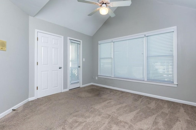 carpeted spare room featuring ceiling fan and lofted ceiling