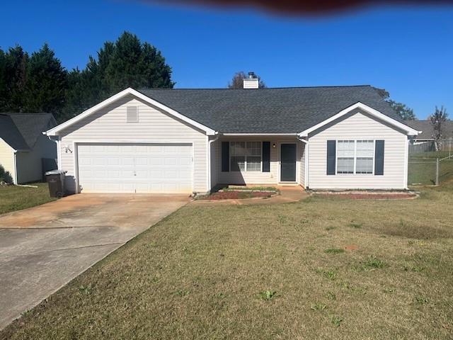 ranch-style home with a garage and a front yard