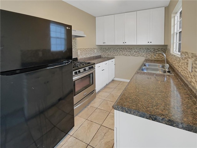 kitchen with black refrigerator, sink, stainless steel range with gas cooktop, and white cabinets