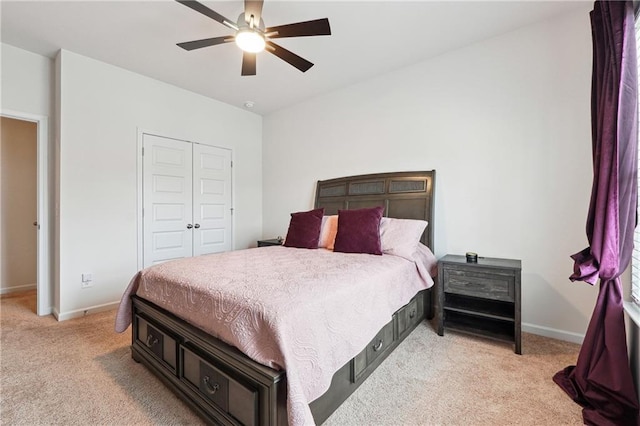 bedroom featuring light carpet, ceiling fan, and a closet