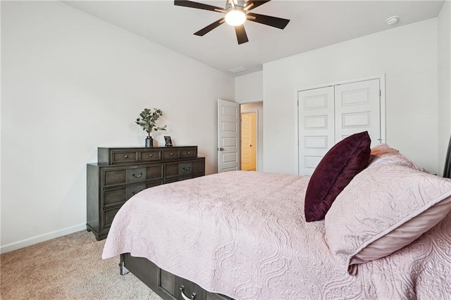 carpeted bedroom featuring ceiling fan and a closet