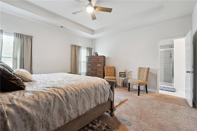 bedroom with light carpet, a raised ceiling, and ceiling fan