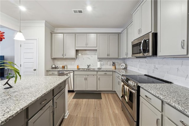 kitchen featuring light stone counters, sink, gray cabinetry, and appliances with stainless steel finishes