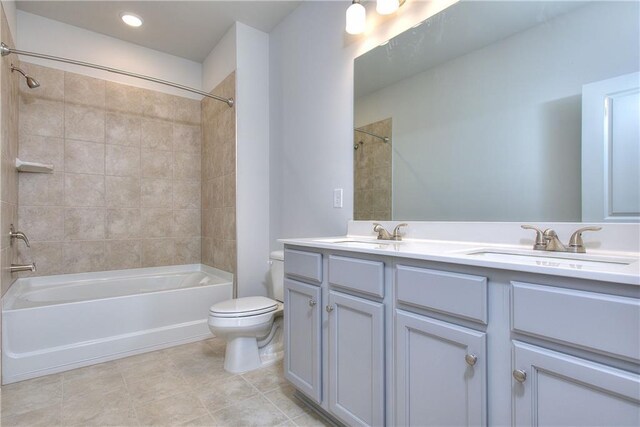 full bathroom featuring tile patterned floors, toilet, vanity, and tiled shower / bath