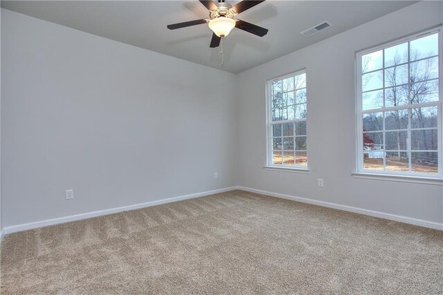 unfurnished room featuring ceiling fan, carpet floors, and a healthy amount of sunlight