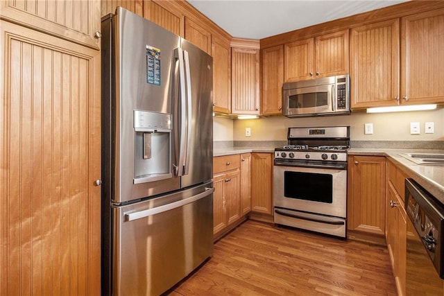 1133 Church St Unit 1, Covington, GA 30014 - kitchen with stainless steel appliances, light wood-style floors, light countertops, and brown cabinets