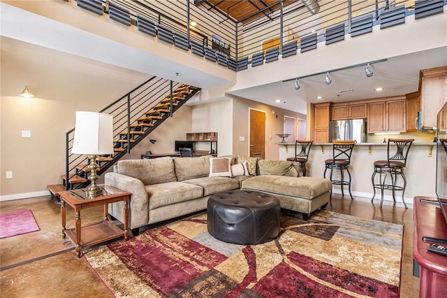 1133 Church St Unit 1, Covington, GA 30014 - living room featuring baseboards, stairway, finished concrete floors, a high ceiling, and track lighting