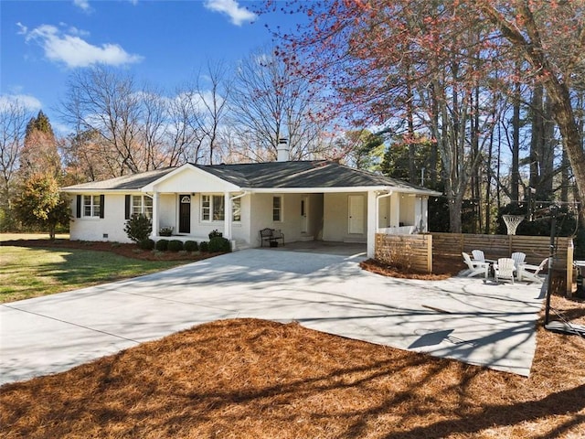 view of front of home with a front yard, driveway, a chimney, and fence