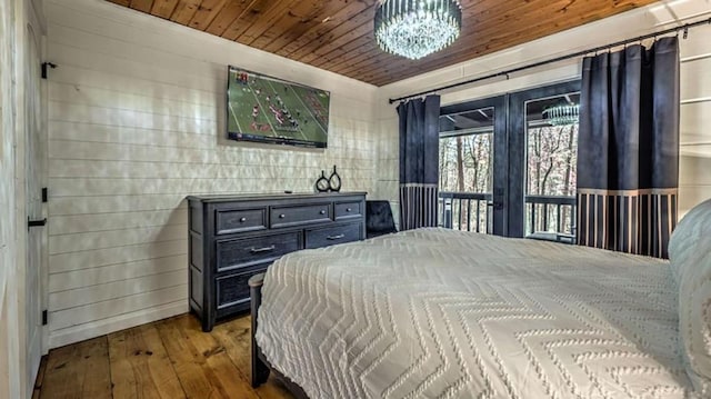 bedroom with hardwood / wood-style floors, access to outside, a notable chandelier, and wood ceiling