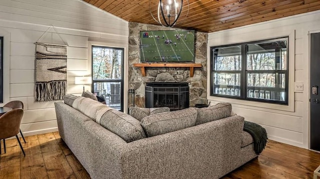 living room featuring wooden walls, a stone fireplace, hardwood / wood-style flooring, vaulted ceiling, and wooden ceiling