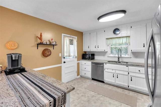 6863 Recreation Ln, Acworth, GA 30102 - kitchen featuring appliances with stainless steel finishes, a sink, white cabinets, and light stone counters