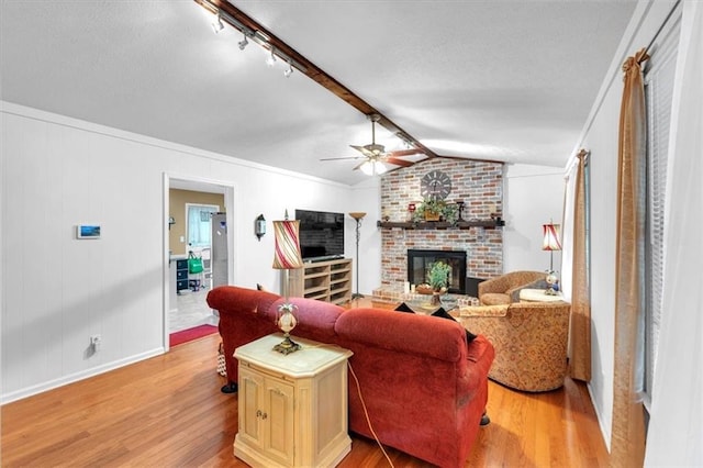 6863 Recreation Ln, Acworth, GA 30102 - living area with a brick fireplace, light wood-type flooring, ceiling fan, baseboards, and a textured ceiling