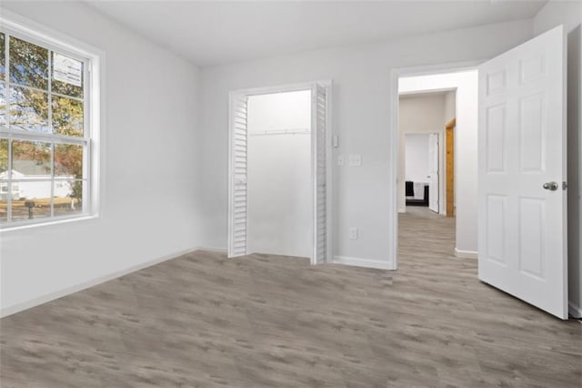 unfurnished bedroom with a closet and light hardwood / wood-style flooring