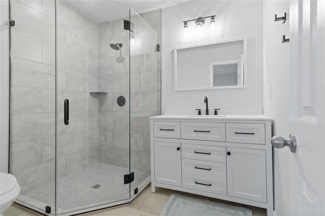 bathroom featuring vanity, toilet, and a shower with door