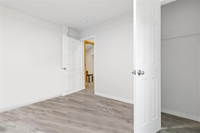 unfurnished bedroom with hardwood / wood-style flooring and a closet