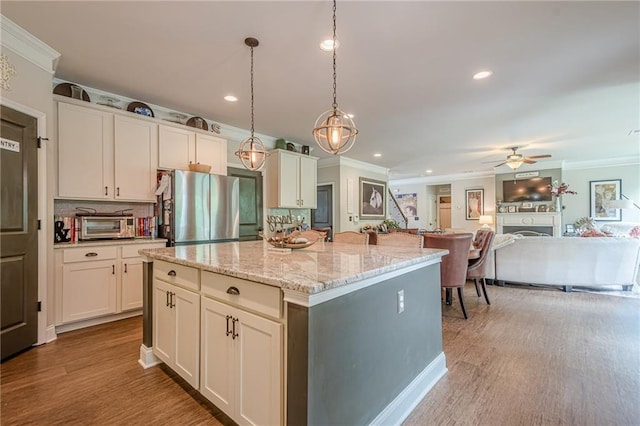 285 Turtle Rock Pl, Acworth, GA 30101 - kitchen featuring freestanding refrigerator, crown molding, white cabinets, wood finished floors, and a fireplace