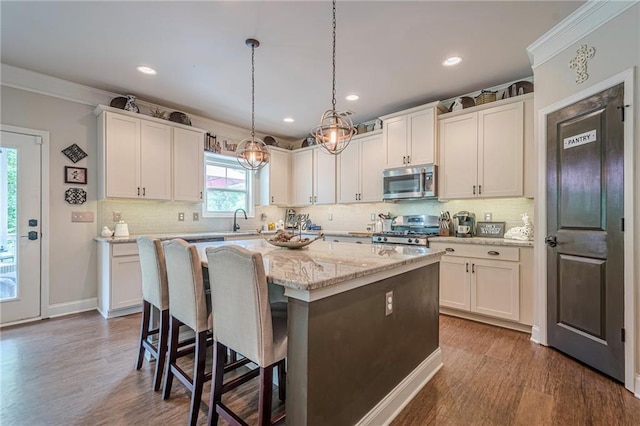 285 Turtle Rock Pl, Acworth, GA 30101 - kitchen with appliances with stainless steel finishes, a sink, dark wood-type flooring, white cabinets, and ornamental molding