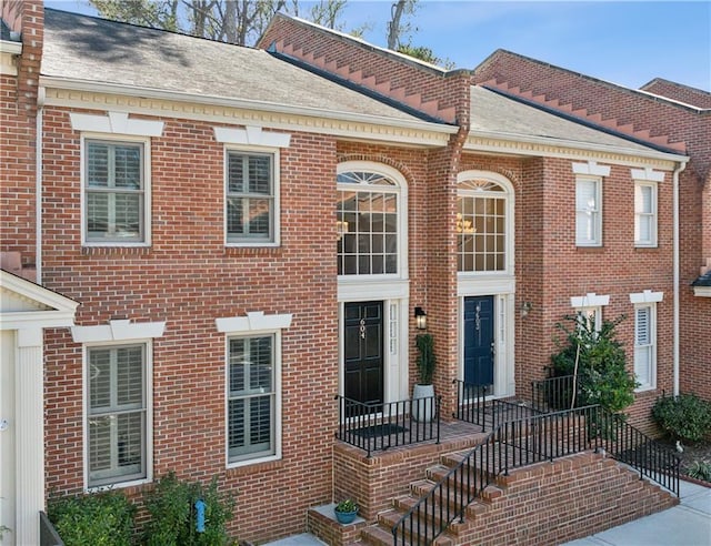 georgian-style home with brick siding and a shingled roof