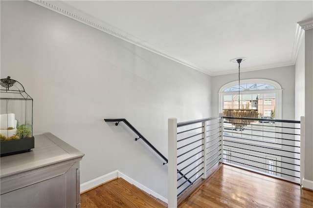 stairs with baseboards, wood finished floors, and ornamental molding