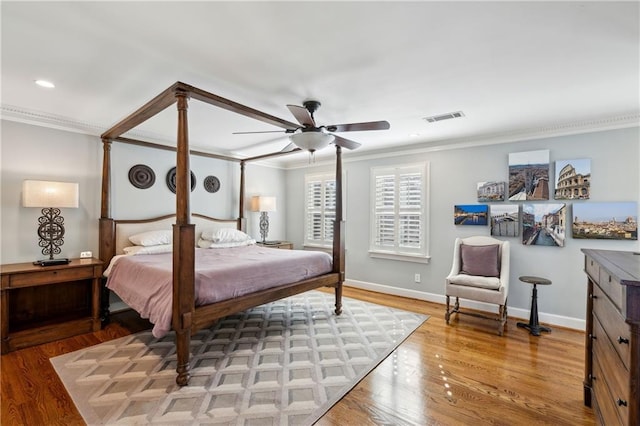 bedroom featuring wood finished floors, visible vents, baseboards, recessed lighting, and crown molding