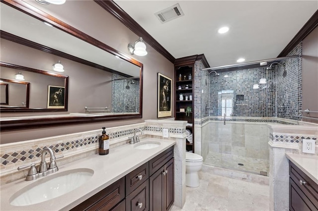 bathroom featuring crown molding, visible vents, a shower stall, and a sink