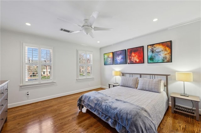 bedroom with wood finished floors, visible vents, and baseboards