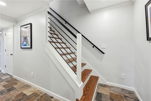 stairs featuring stone tile flooring, crown molding, and baseboards