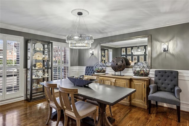 dining area featuring a healthy amount of sunlight, wood finished floors, and wainscoting