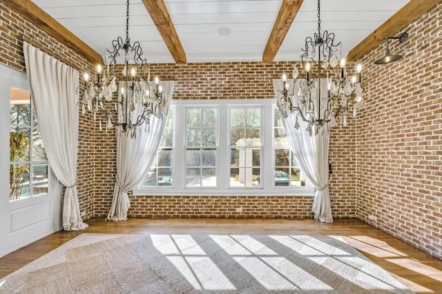 unfurnished dining area with a chandelier, brick wall, beam ceiling, and light wood-style flooring