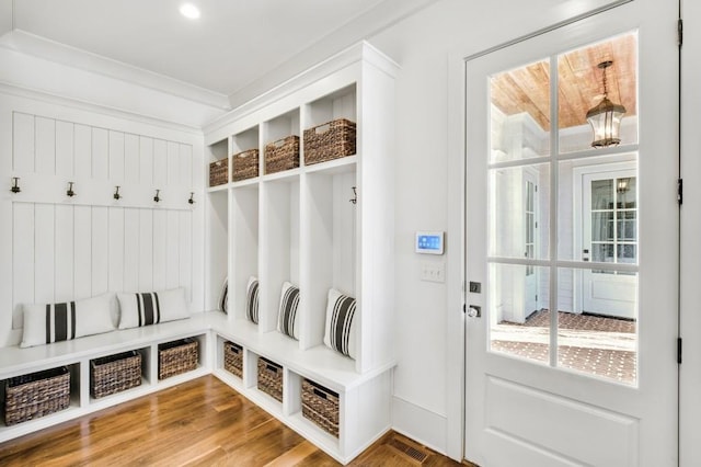 mudroom with wood finished floors and crown molding