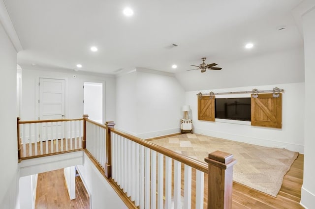 hall featuring recessed lighting, wood finished floors, and an upstairs landing