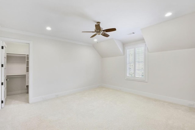 additional living space featuring light carpet, visible vents, and baseboards