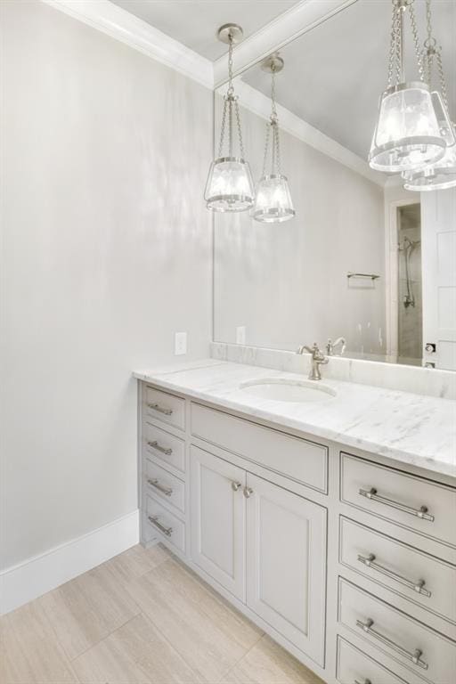 bathroom with a shower, ornamental molding, vanity, and baseboards