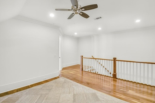 empty room with recessed lighting, wood finished floors, visible vents, and crown molding