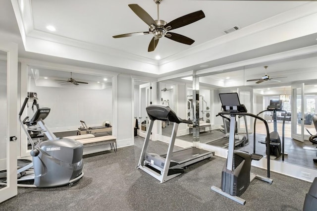 exercise room with ornamental molding, a raised ceiling, visible vents, and recessed lighting