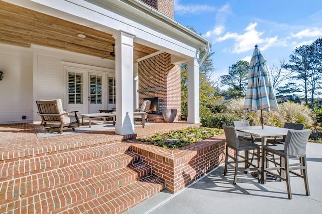 view of patio featuring a warm lit fireplace