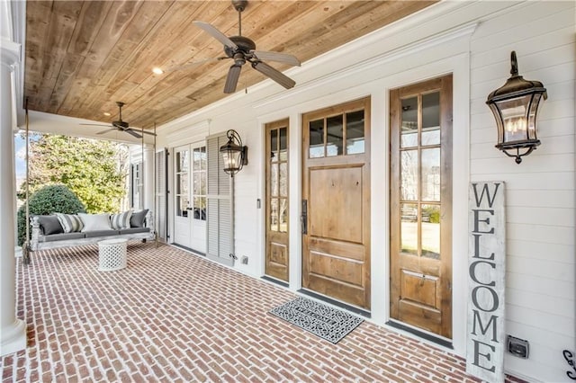 entrance to property with covered porch and ceiling fan