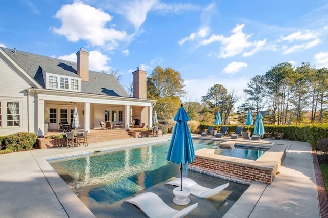 pool featuring a patio area, an in ground hot tub, and french doors