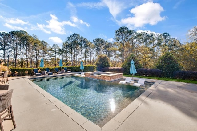 view of pool featuring a pool with connected hot tub and a patio