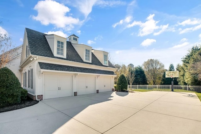 view of property exterior with roof with shingles, fence, driveway, and an attached garage