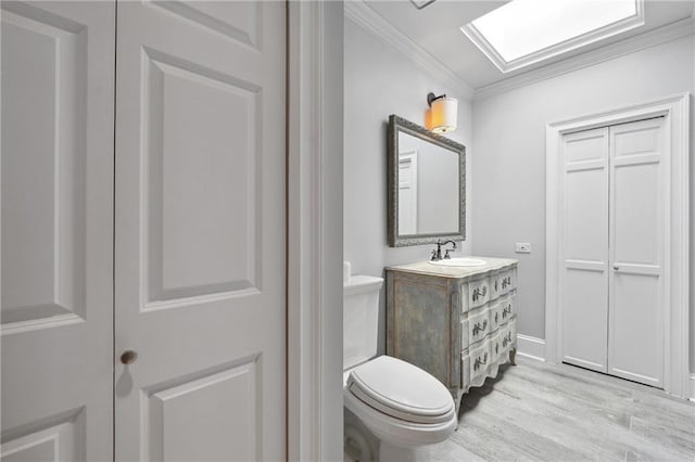 3636 Peachtree Rd NE Unit 405, Atlanta, GA 30319 - half bathroom featuring crown molding, wood finished floors, vanity, and a skylight