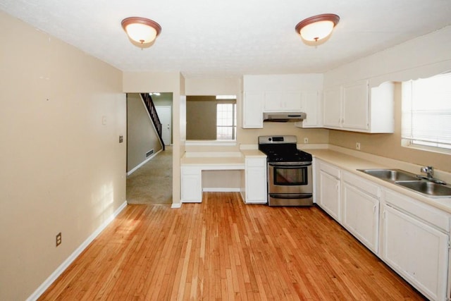 kitchen featuring white cabinetry, sink, stainless steel range oven, and light wood-type flooring