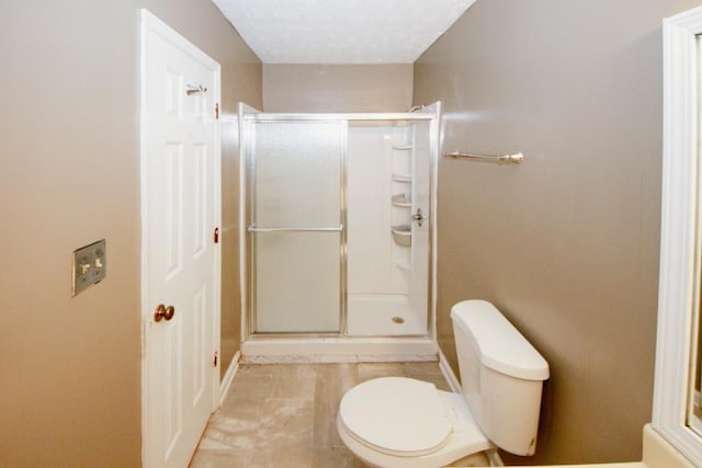 bathroom with a shower with door and toilet