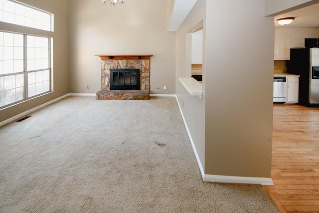 unfurnished living room featuring light colored carpet and a fireplace