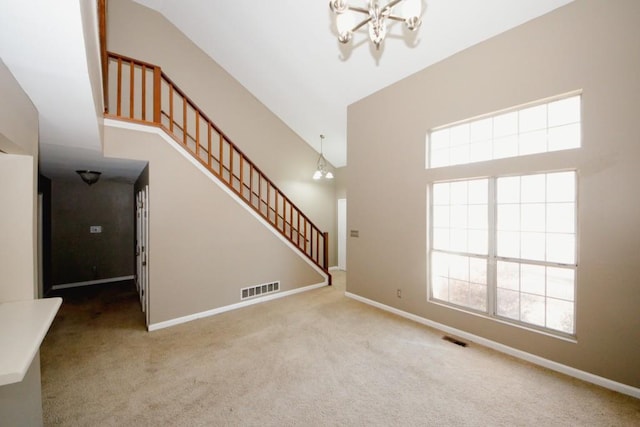 interior space featuring carpet floors, a towering ceiling, and a wealth of natural light